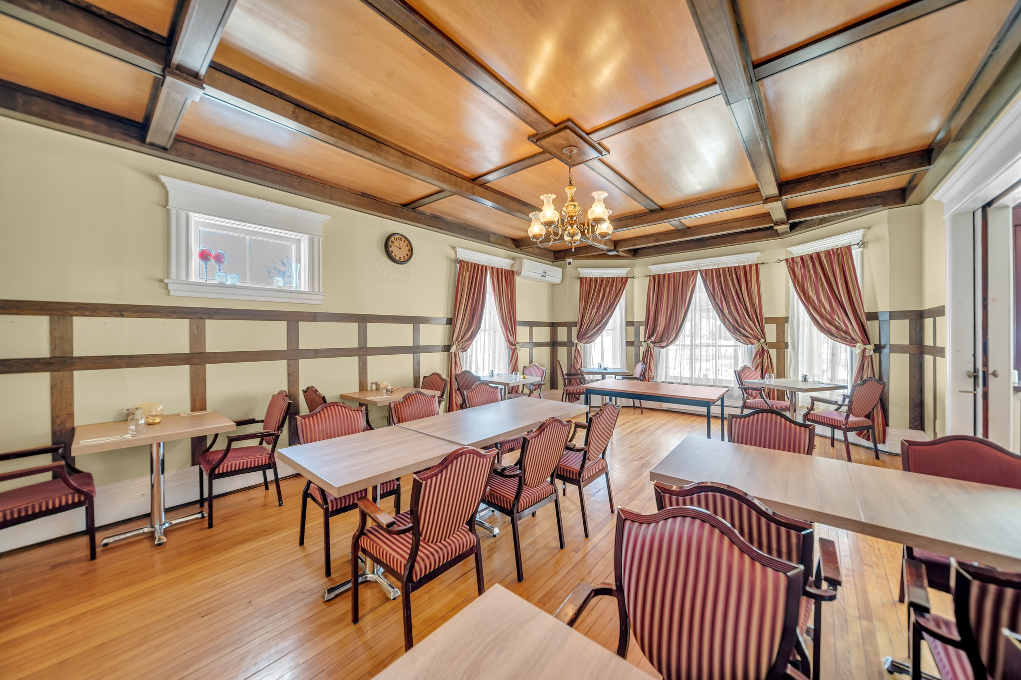 Victorian Diner in Marmora. Large bright room with tables and red and white striped chairs and large windows with curtains.