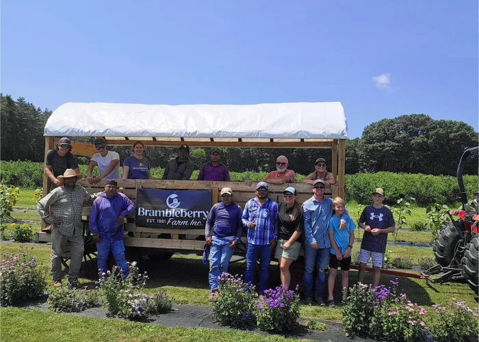 photo of the Brambleberry farm team in front of a farmstand