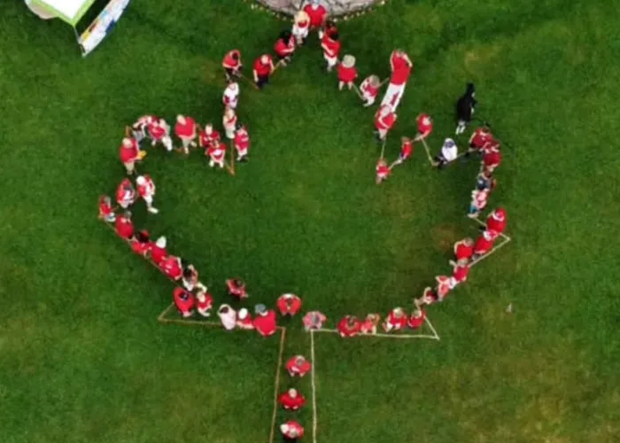 people lined up to make the shape of Canadian flag