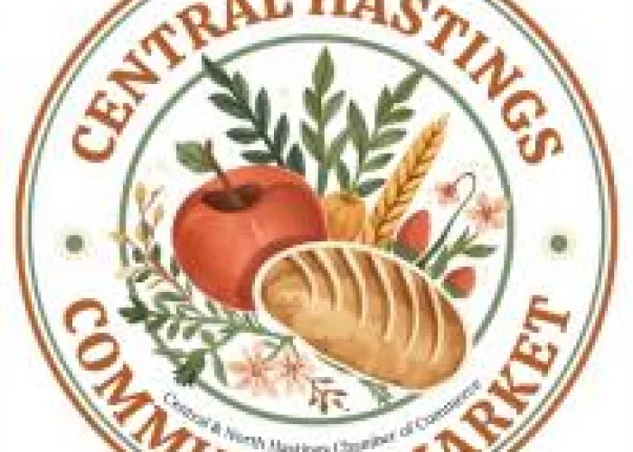 Apple, loaf of bread, wheat, greenery at the centre of a round Central Hastings Community Market Logo