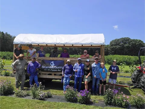photo of the Brambleberry farm team in front of a farmstand
